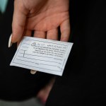 A patient holds an envelope containing medical abortion pills.