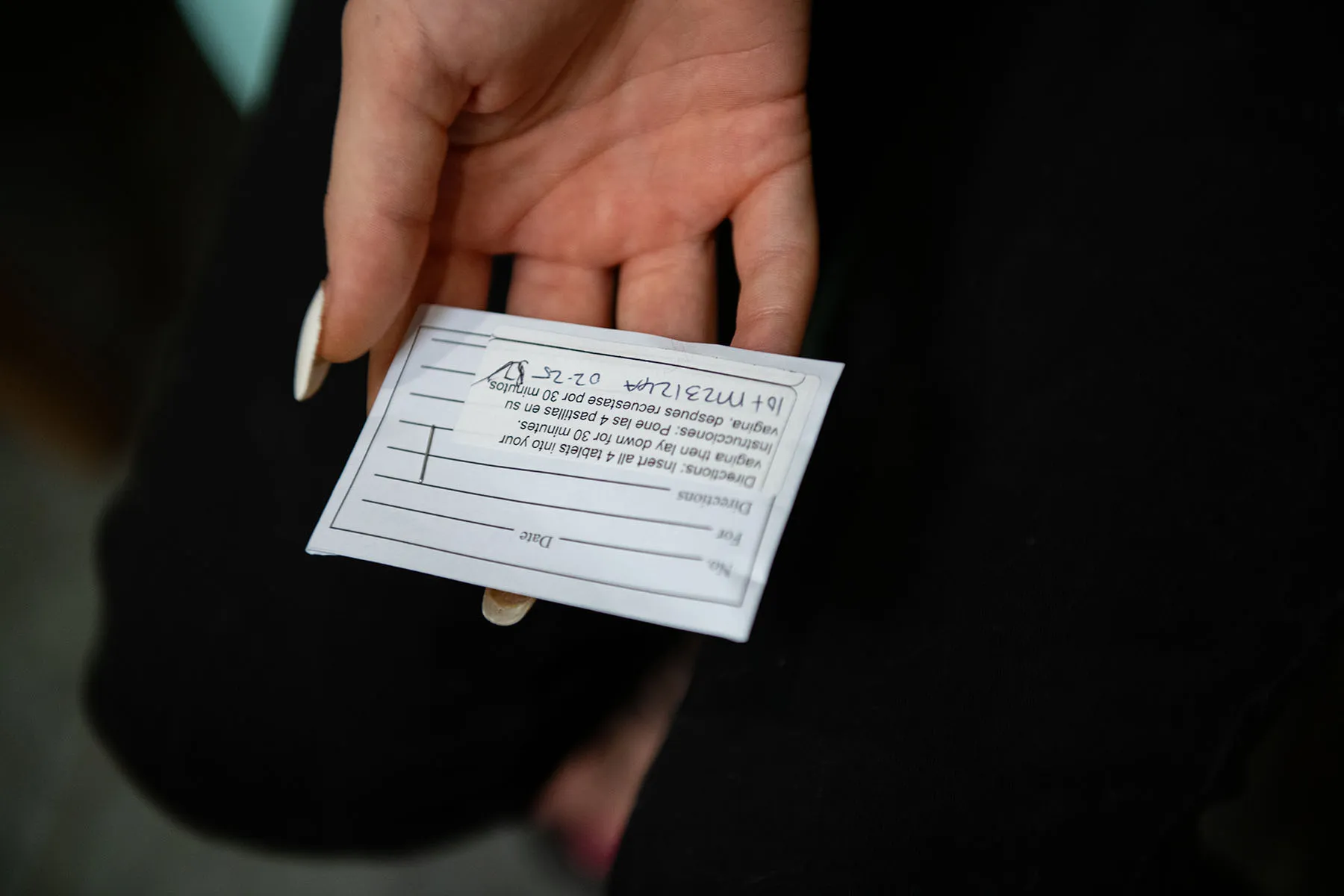 A patient holds an envelope containing medical abortion pills.