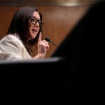 Lori Chavez-DeRemer speaks and points while sitting at a table.