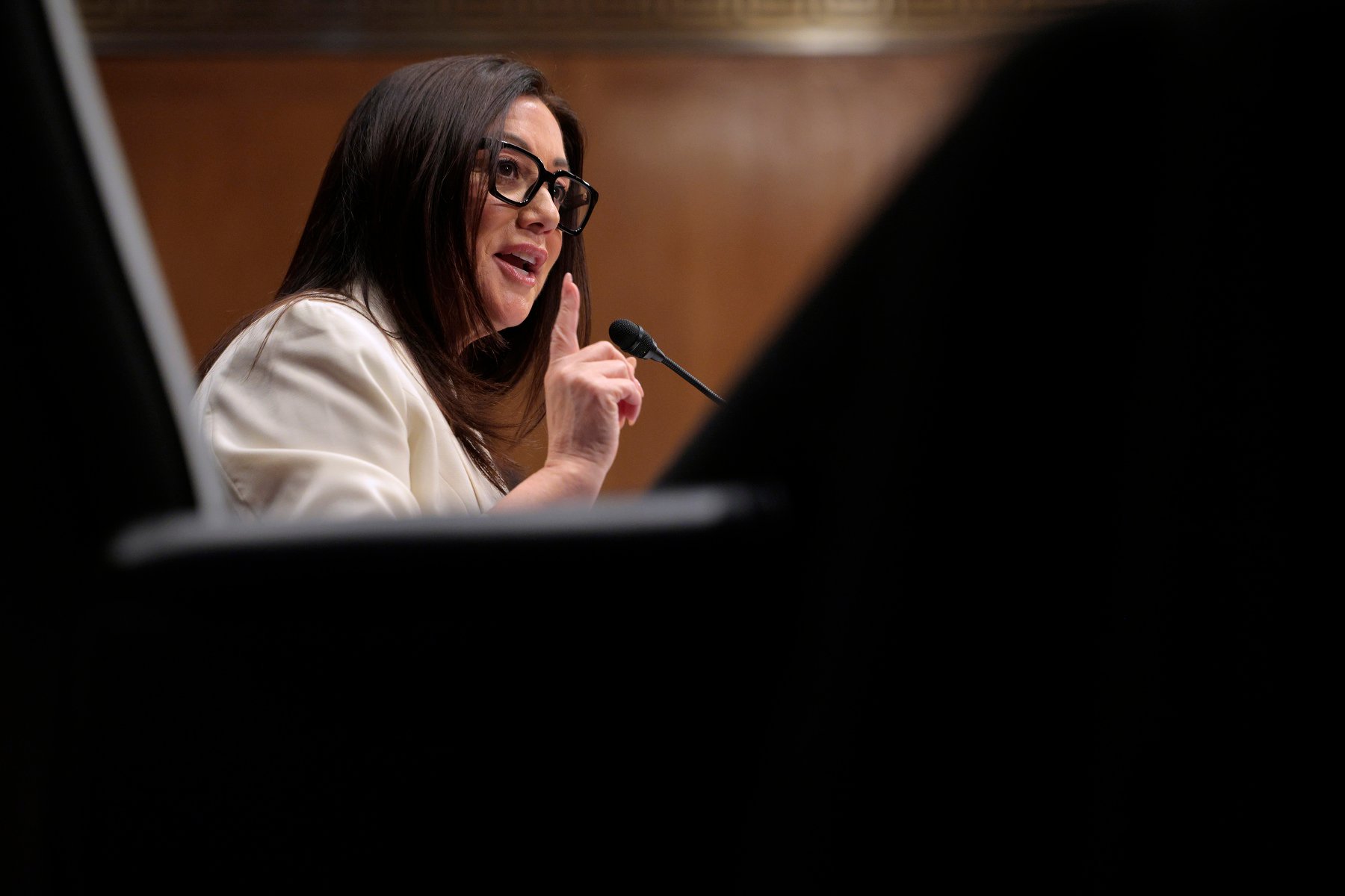 Lori Chavez-DeRemer speaks and points while sitting at a table.