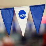 Blue and white NCAA-branded banners hang at a swim meet.