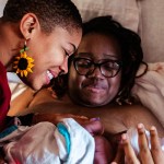 Danielle Lyles Barton, postpartum specialist and doula, comforts her client and welcomes the new baby following birth.