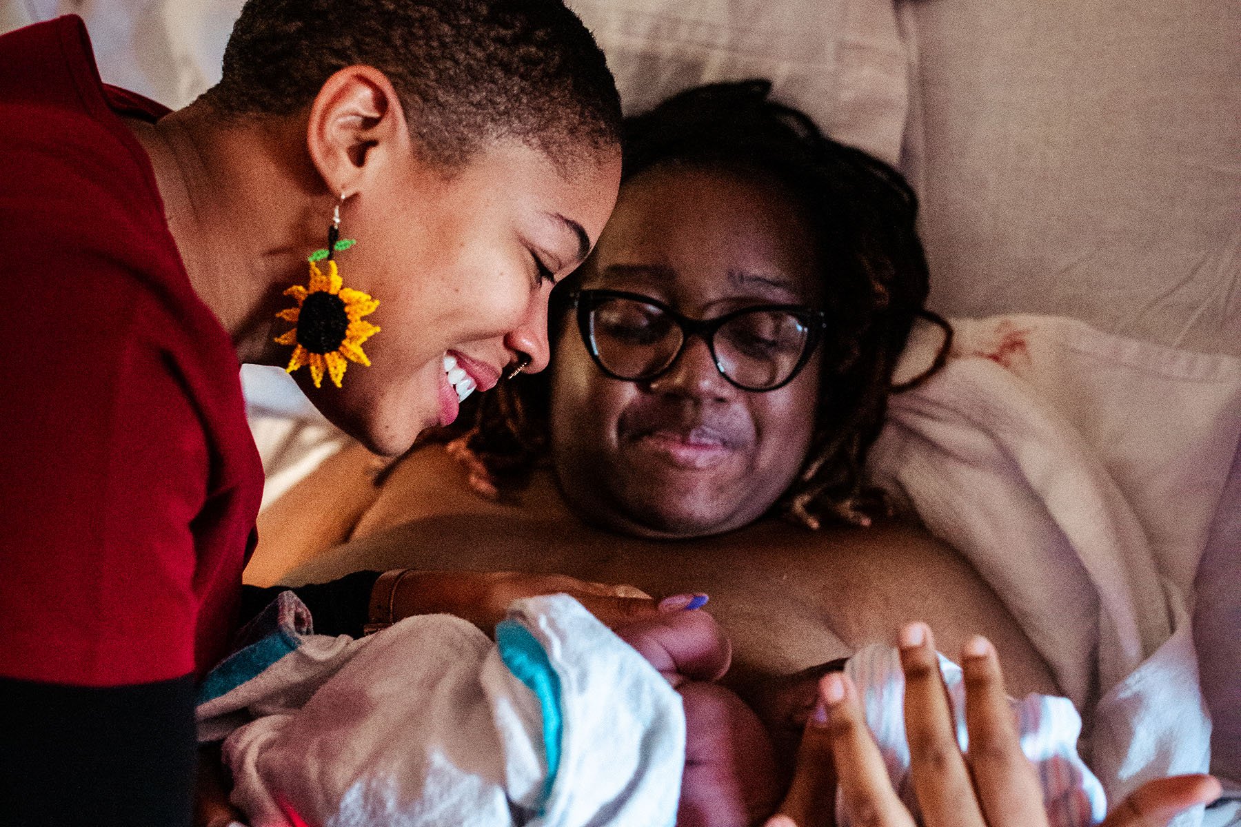 Danielle Lyles Barton, postpartum specialist and doula, comforts her client and welcomes the new baby following birth.