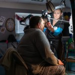 A doctor gives a person an eye exam in a clinic setting.