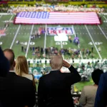 President Donald Trump salutes as Jon Batiste performs the national anthem at the NFL Super Bowl 59 football game between the Philadelphia Eagles and the Kansas City Chiefs.