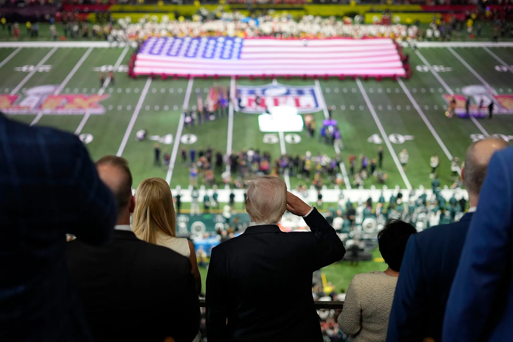 President Donald Trump salutes as Jon Batiste performs the national anthem at the NFL Super Bowl 59 football game between the Philadelphia Eagles and the Kansas City Chiefs.