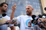 A man points angrily in front of cameras.