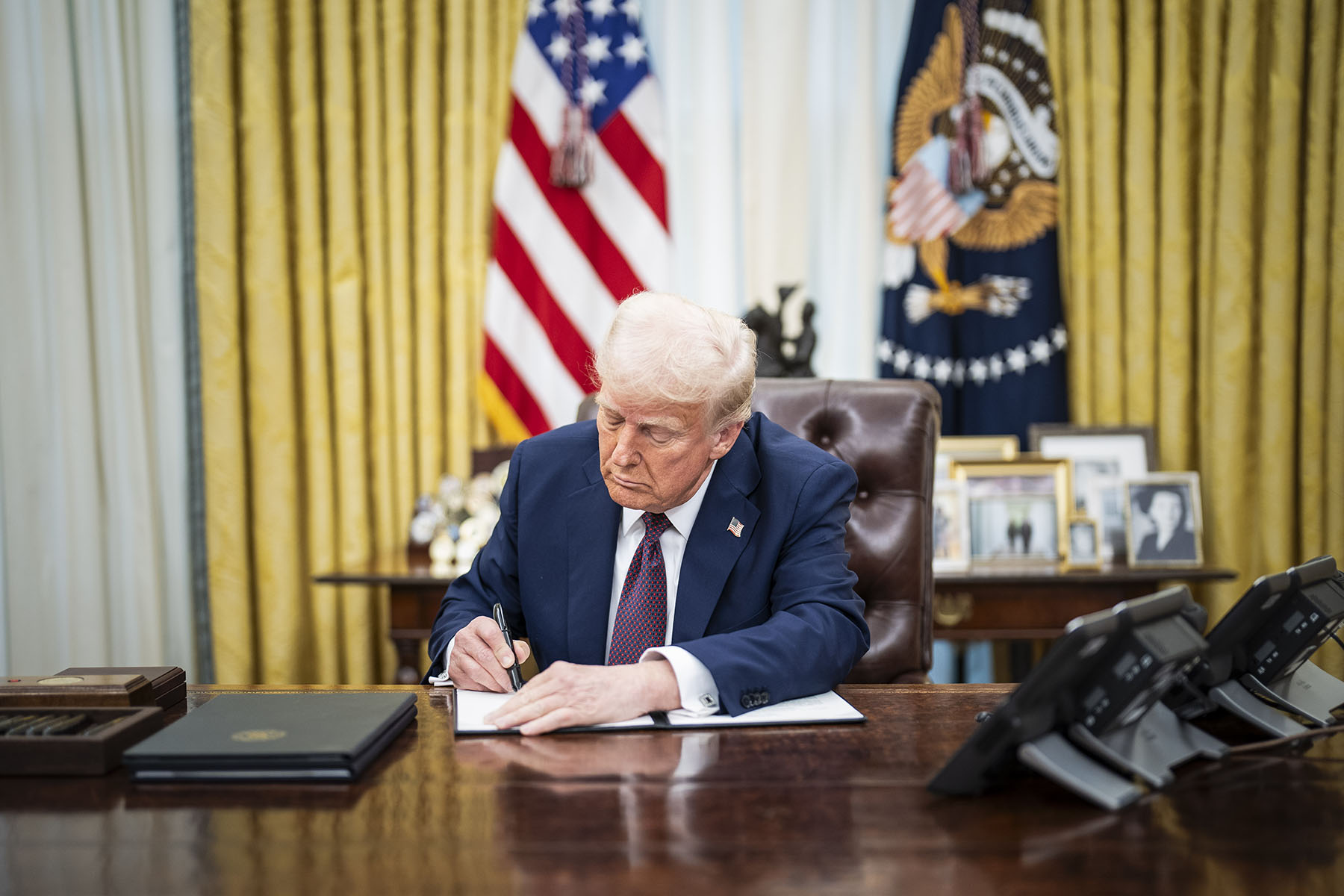 President Trump signs executive orders in the Oval Office at the White House.