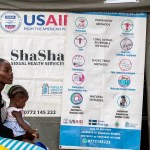 A woman sits with a child at a health care clinic.