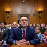 Russell Vought sits at a confirmation hearing.