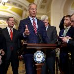 Sen. John Thune stands at a lectern and speaks to reporters