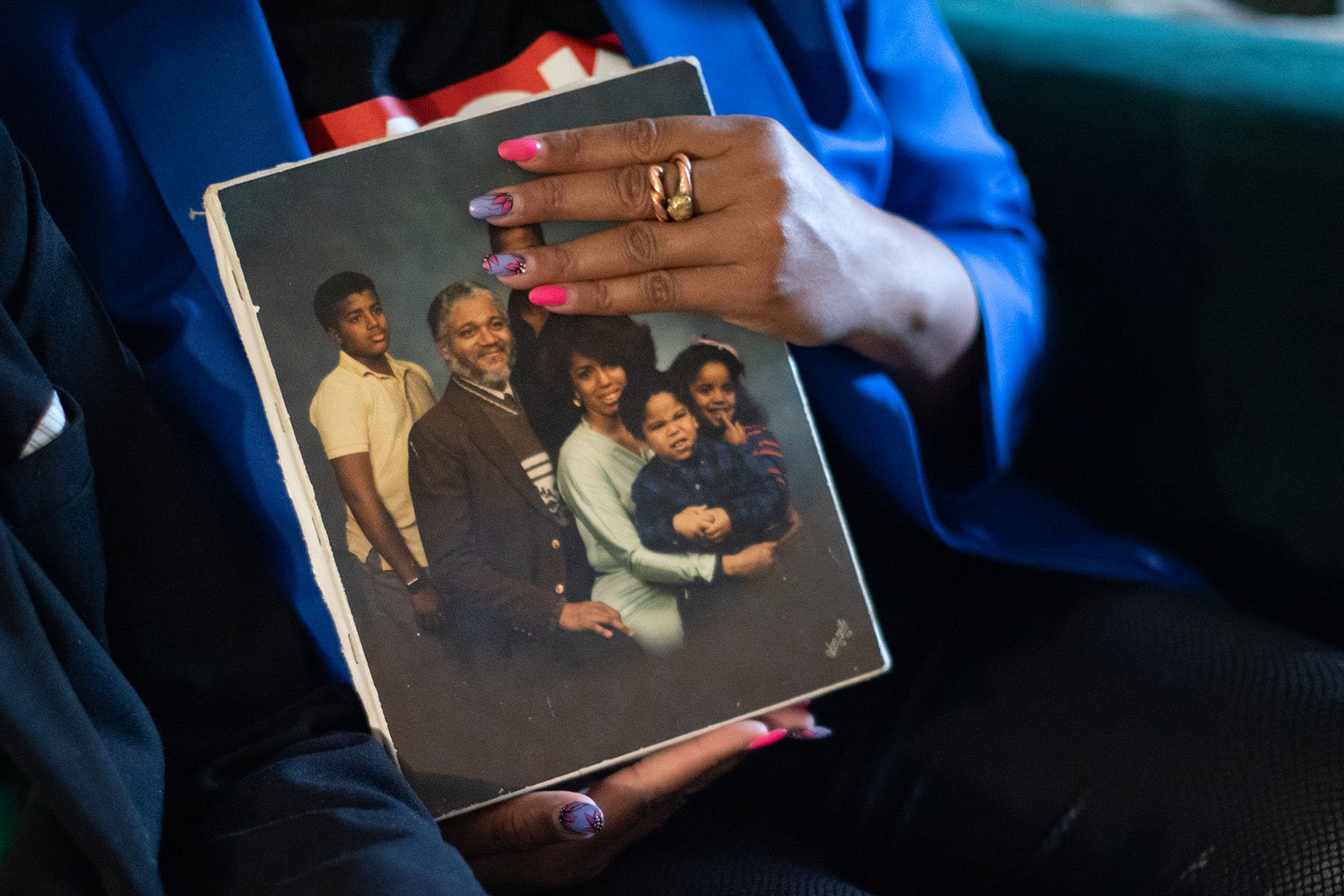 Zakiya Jackson holds up a family portrait at home in Washington, D.C.