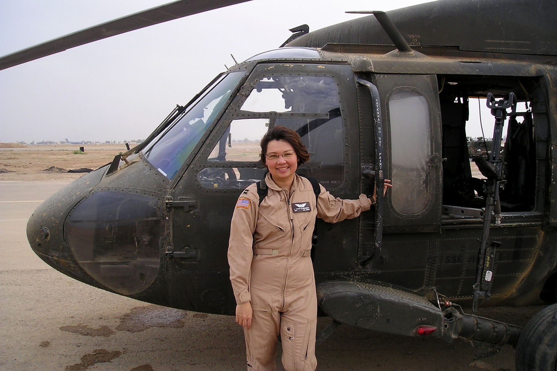 Tammy Duckworth poses in front of a helicopter during her time in the Illinois Army National Guard.