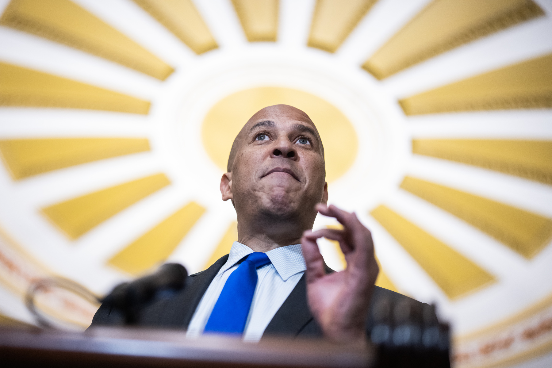 Senator Cory Booker gestures at a podium.