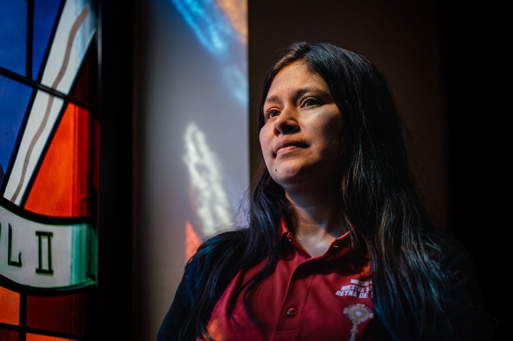 Ruano stands near a stained glass window inside her Milwaukee church.