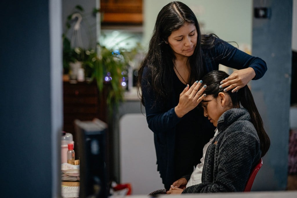 Ruano helps her daughter get ready for school at home in the early morning.