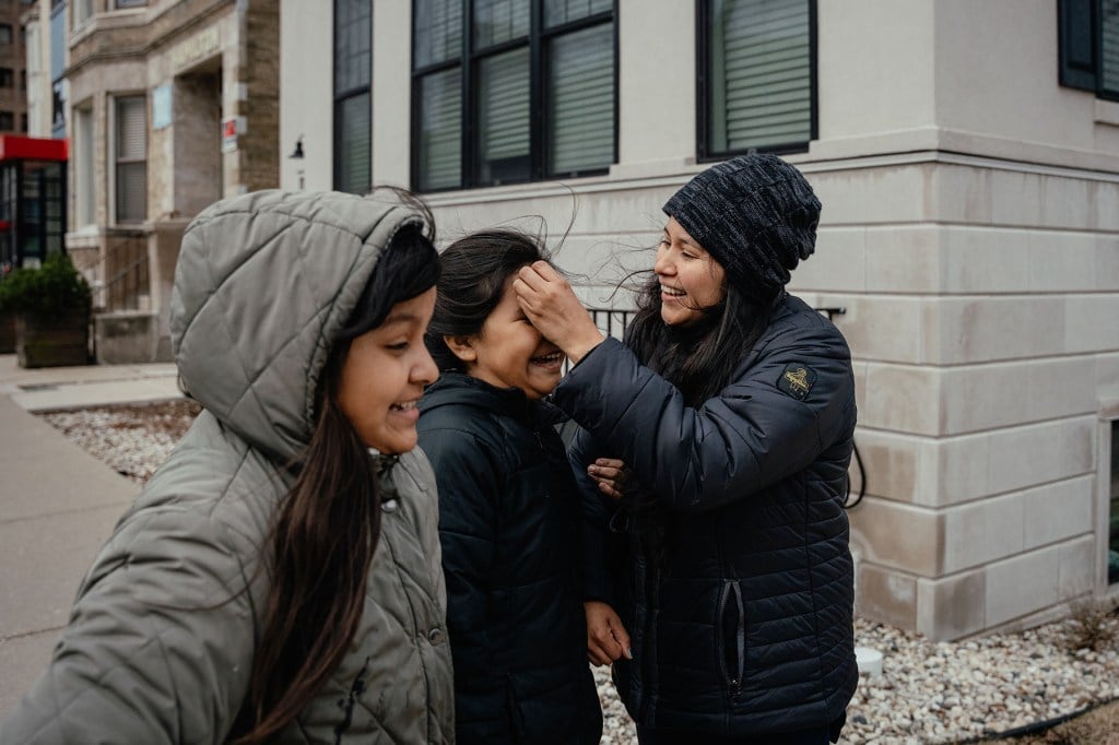 Yessenia Ruano and her daughters walk down a city sidewalk near the ICE field office.