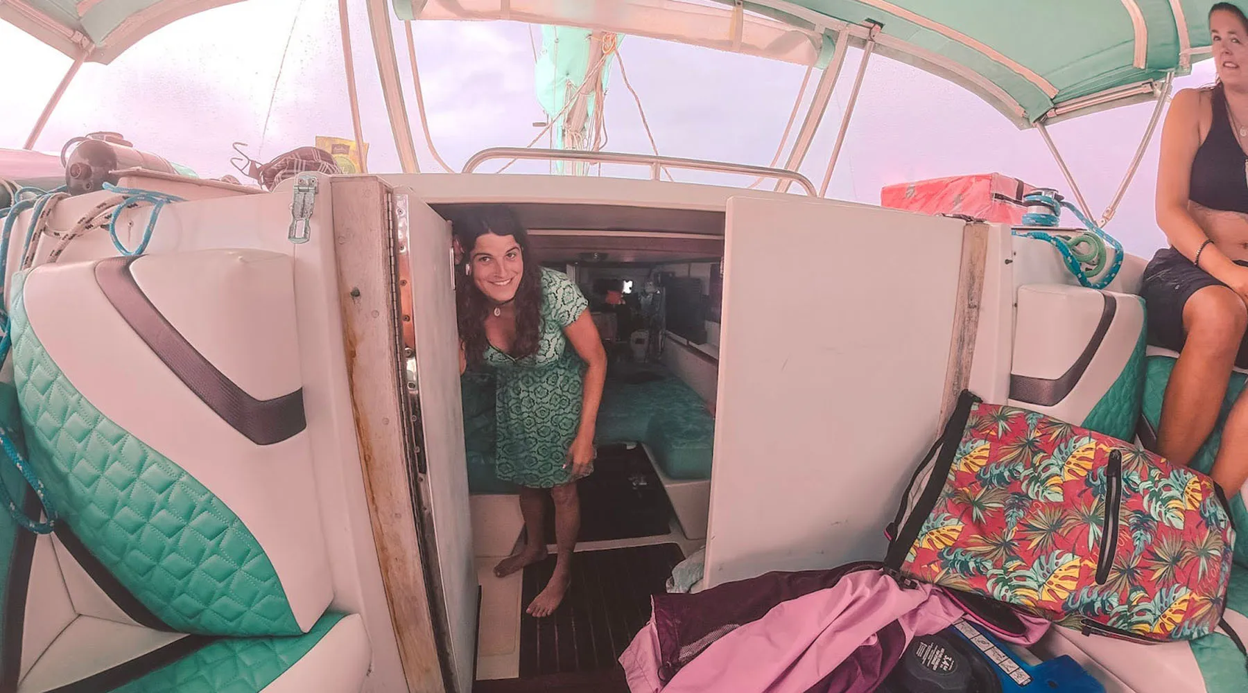 Kelsey Granger smiles as she stands in the doorway leading below deck on a sailboat.