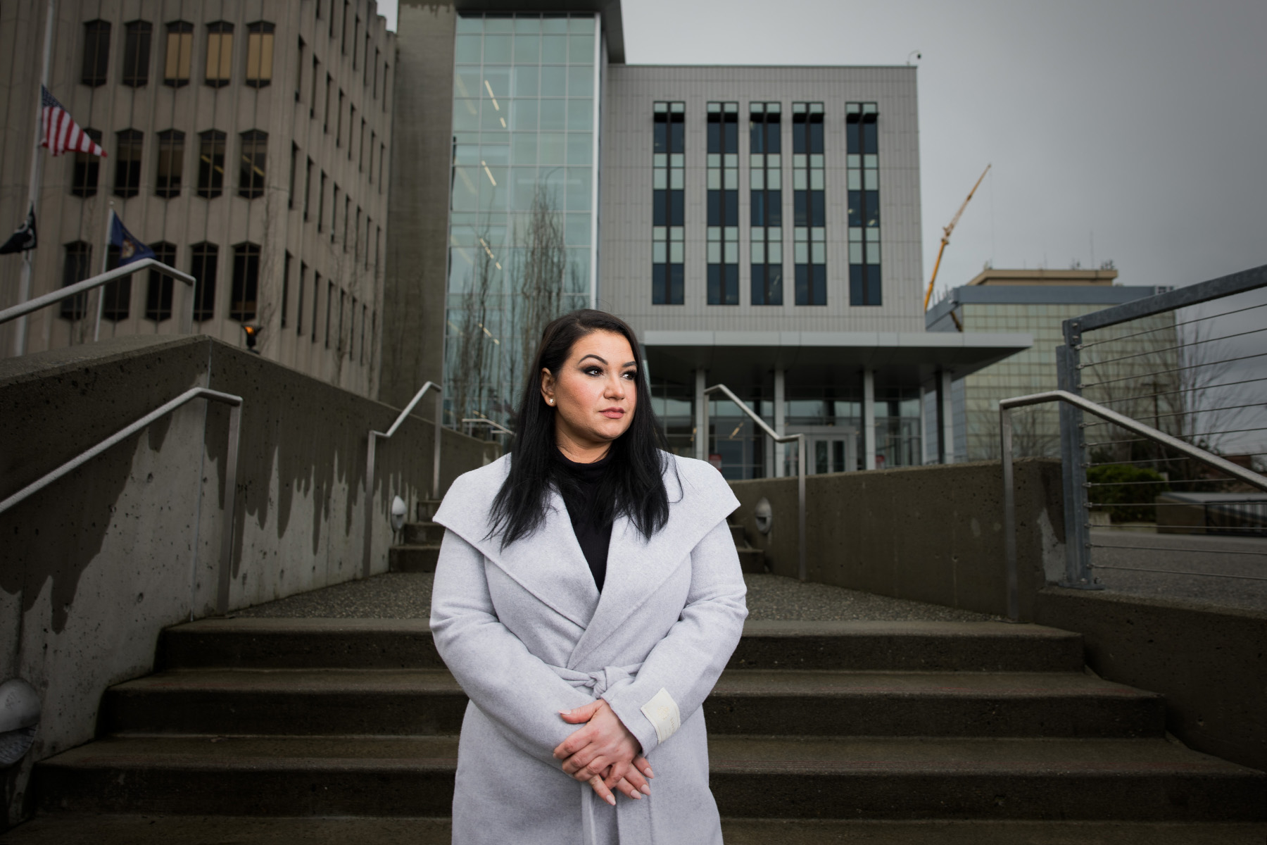 A woman stands at the steps of a courthouse.