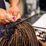 Closeup of a woman braiding hair.