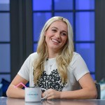 Isabel Brown smiles while seated at a news desk.