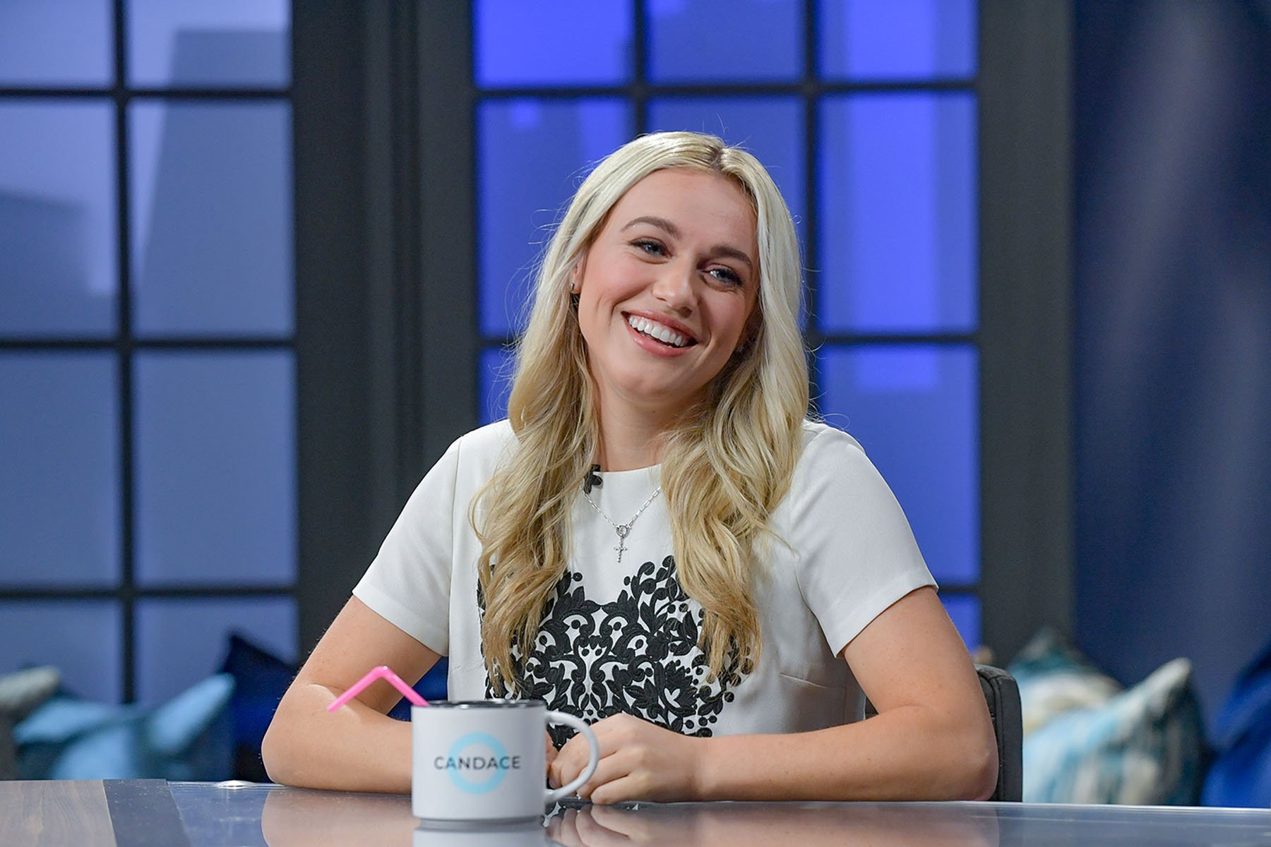 Isabel Brown smiles while seated at a news desk.