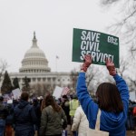 Federal workers hold signs in a rally at Upper Senate Park in Washington, D.C.