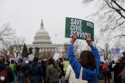 Federal workers hold signs in a rally at Upper Senate Park in Washington, D.C.