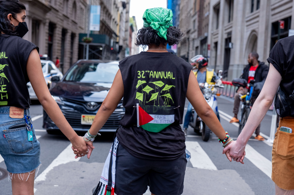 People attending the march hold hands in front of traffic on a New York City street.