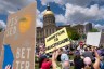 Protestors raise signs in front of the Georgia state capitol building.