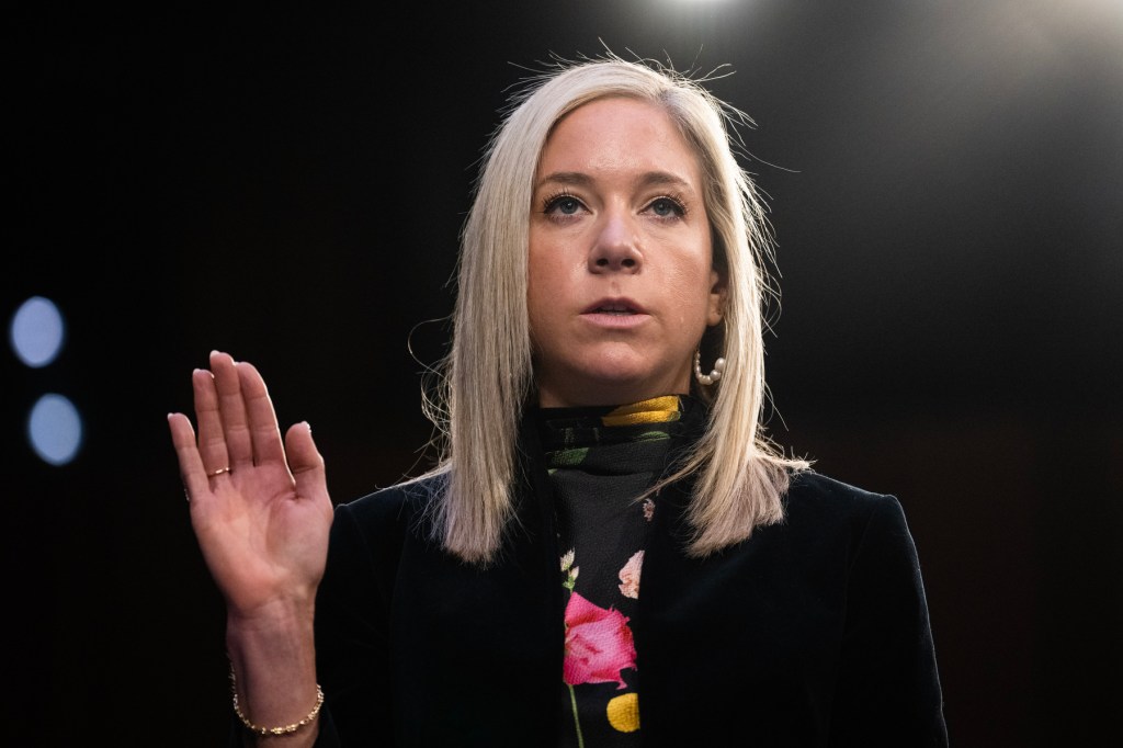 A woman raises her hand to give testimony.