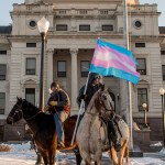 Two protestors on horseback in front of the South Dakota capitol building.