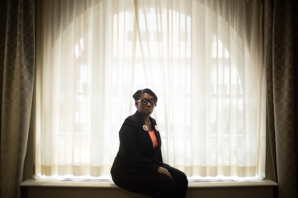 A woman sits a in a window.