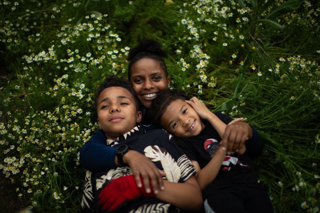 A farmer on her farm holding her two children.