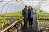 Two people stand for a portrait on their farm.