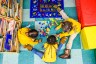 Three little kids play in a circle in a day care center.