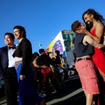 People dance and laugh together at an outdoor day party.