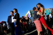 People dance and laugh together at an outdoor day party.