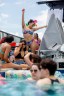 People sit and swim near and in a pool.