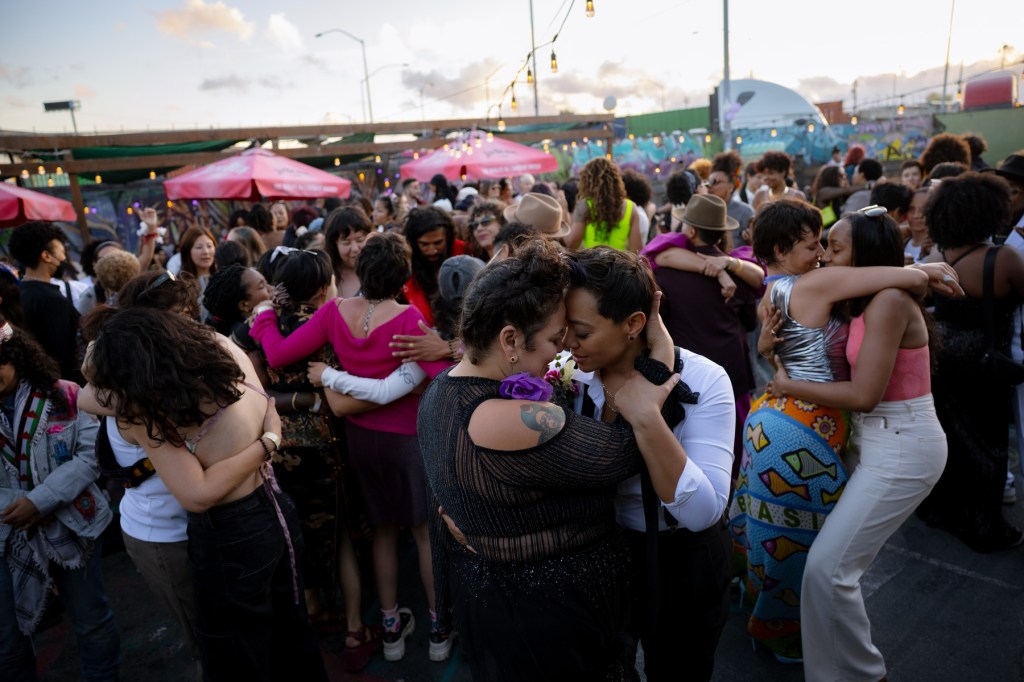 Several people slow dance as the sun sets.