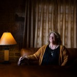 Cheryl Thompson sits on a couch as she poses for a portrait near her home.