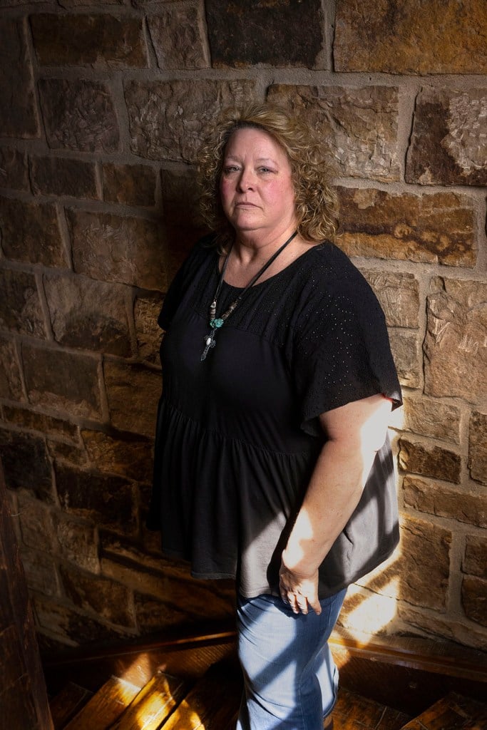 Cheryl Thompson leans against a stone wall as she poses for a portrait near her home in Southern Illinois.