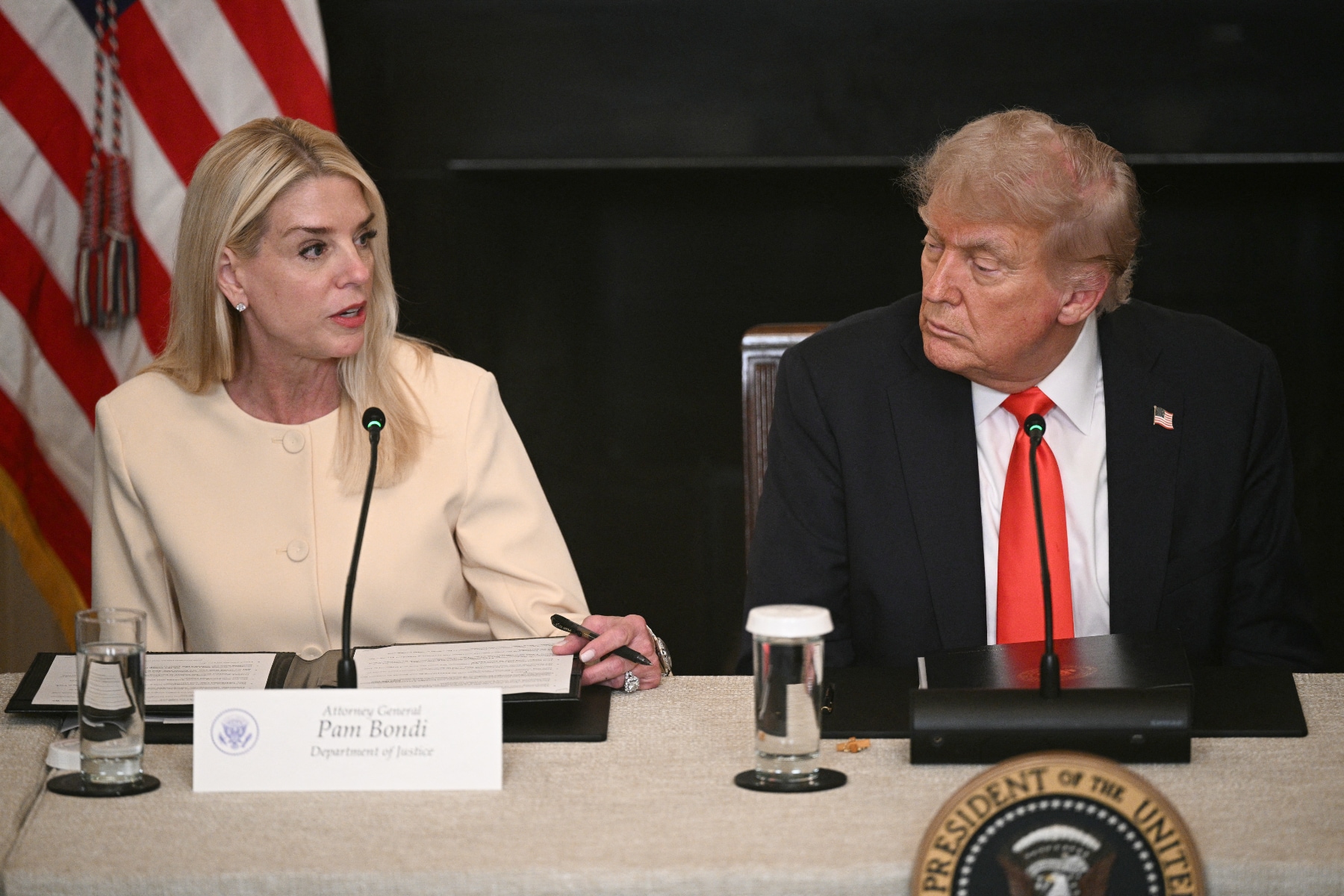 Pam Bondi, the attorney general, sits next to President Donald Trump.