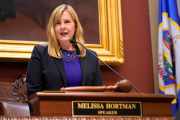 La representante Melissa Hortmann, usa una chaqueta oscura y una camisa morada, que se dirige al Consejo Legislativo en Minnesota como oradora en 2023.