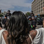A woman raises her hands in front of Los Angeles Mounted Police officers during the No Kings Day protests taking place across the nation.
