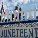 Children wave from a float that says Juneteenth.