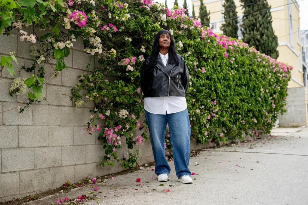Michelle West stands near a wall of flowers.