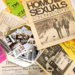 A display of archival photos, fliers and newspapers spread out.