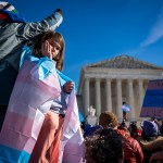 A child looks out at the crowd during a protest in support of care for transgender youth outside the Supreme Court during the United States v. Skrmetti arguments.