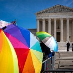 People with rainbow umbrellas protest in support of care for transgender youth outside the Supreme Court during the United States v. Skrmetti arguments.